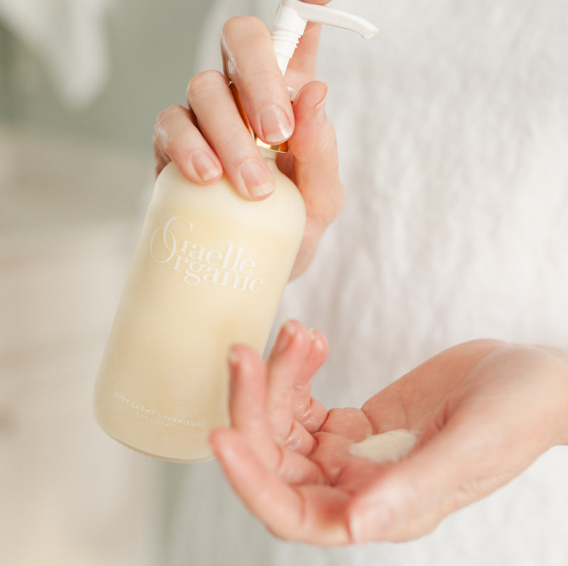 Hands Holding and Dispensing Body Moisturizer